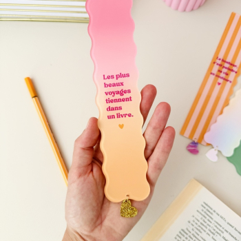 Marque-page en plexiglas rose et orange avec citation sur les livres et les voyages