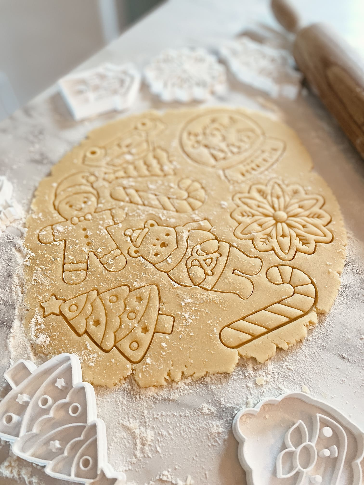 P&acirc;te &agrave; bredele marqu&eacute;e de motifs de No&euml;l : sapin, bonhomme de neige, sucre d'orge et flocon
